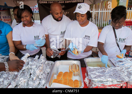 Miami Florida, Little Haiti, Caribbean Market Place Karneval, Marktplatz, Gemeinde Schwarzer Mann Männer männlich, Frau weibliche Frauen, Freiwillige Freiwillige ehrenamtlich Stockfoto