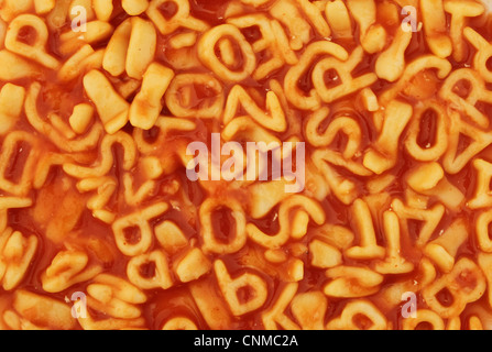 Nahaufnahme des Alphabets Spaghetti in Tomatensauce als Hintergrund und Struktur Stockfoto