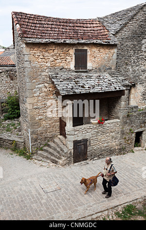 Mann zu Fuß Hund auf Straße, Cite De La Couvertoirade, Aveyron, Frankreich Stockfoto