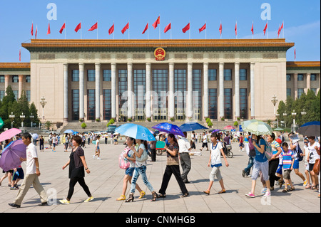 Chinesische Touristen in dem Tiananmen-Platz mit der großen Halle des Volkes in den Hintergrund. Stockfoto