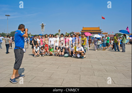 Eine Gruppe von chinesischen Touristen am Tiananmen-Platz mit fotografieren, ist der Eingang der verbotenen Stadt im Hintergrund. Stockfoto