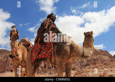 Ein Beduine vor den königlichen Gräbern in Petra Touristen für eine Fahrt mit seinen Kamelen Jordanien mieten wollen. Stockfoto