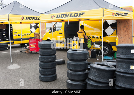 Qualifizierte Dunlop Reifen Mechanik arbeiten auf Rennreifen im Fahrerlager am Oulton Park Autorennen Schaltung Cheshire England UK Stockfoto