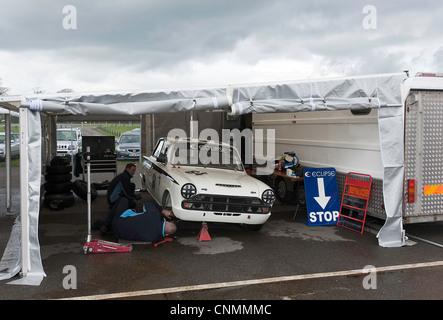 Mechaniker arbeiten auf Ford Lotus Cortina Saloon Rennwagen am Oulton Park Motor Racing Circuit Cheshire England Vereinigtes Königreich UK Stockfoto