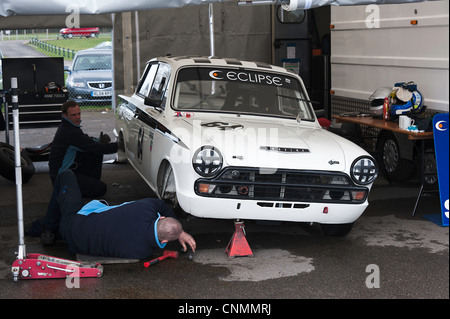 Mechaniker arbeiten auf Ford Lotus Cortina Saloon Rennwagen am Oulton Park Motor Racing Circuit Cheshire England Vereinigtes Königreich UK Stockfoto