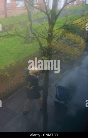 Luftaufnahme durch beschlagene Busfenster der tristen Leben London Mutter unten während der saisonalen Regen Regen. Stockfoto