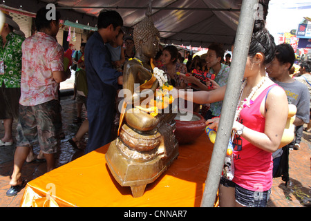 Menschen gießt Wasser über Buddhastatue, Songkran Festival 2012 an der Khao San Road in Bangkok, Thailand Stockfoto