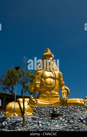 Eine große goldene Shiva-Statue am Eingang zum Koneswaram-Tempel auf Swami Rock in Trincomalee auf Sri Lanka. Stockfoto