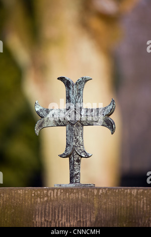 Kleine einfache Metall-Kreuz auf einem Grabstein, geringe Schärfentiefe Feld Zusammensetzung Stockfoto