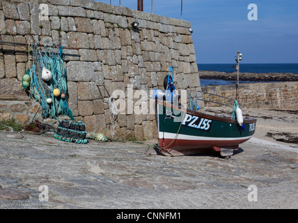 Sennen Cove Lands End Cornwall, Fischerboot und Hafen Wand mit Fischernetzen und Lobster Pot. Cornish Küste Granitwand. Stockfoto