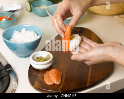 Frau, die Zubereitung von Sushi am Tisch Stockfoto