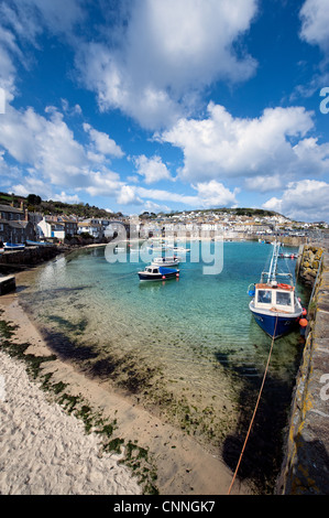 Ein Blick auf die touristische Attraktion, Mousehole Hafen mit Fischerbooten vor Anker & Viilage in der Sonne, Cornwall, UK Stockfoto