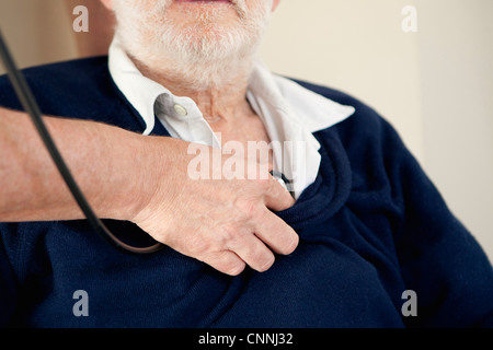 Arzt auf älteren Mannes Herz hören Stockfoto