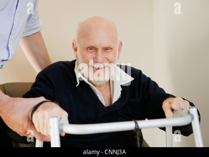 Lächelnder älterer Mann mit walker Stockfoto