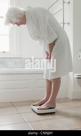 Ältere Frau wiegen sich im Badezimmer Stockfoto