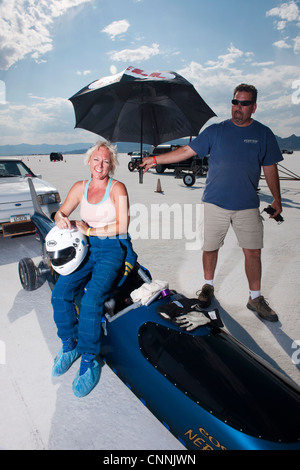 blaues Top Fuel Drag Race Auto mit Frau Treiber Unterständen aus Sonne unter Dach am Bonneville Salt Flat Geschwindigkeit Woche Stockfoto