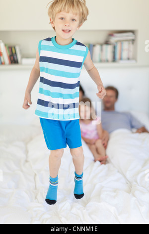 Junge, springen auf dem Bett der Eltern Stockfoto