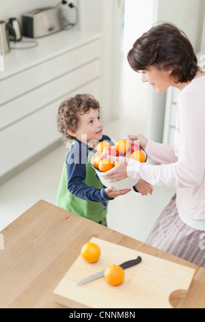 Mutter und Sohn mit Früchten in Küche Stockfoto