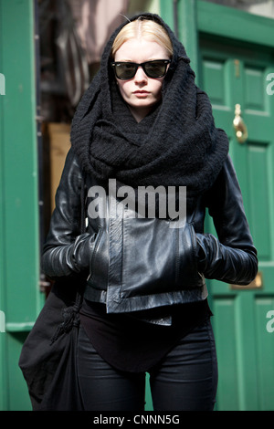 Mittelbild einer jungen, schwarz gekleideten Frau mit Sonnenbrille, Brick Lane, London, England, Großbritannien. Stockfoto