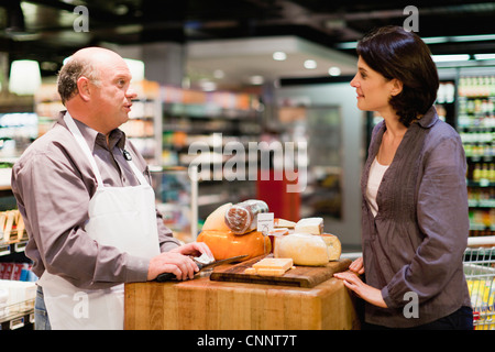 Frau mit kostenlosen Proben im Supermarkt Stockfoto