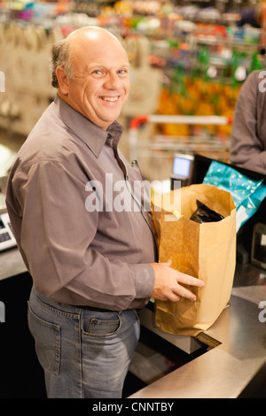Sachbearbeiter Absacken Lebensmittel im Shop Stockfoto