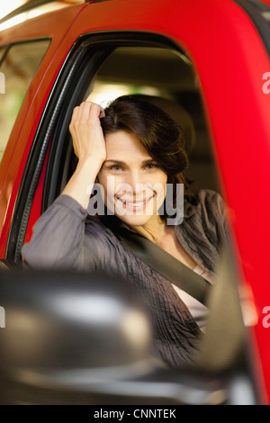 Lächelnde Frau aus Auto gelehnt Stockfoto