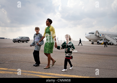 First Lady Michelle Obama geht über den Asphalt mit Megan Soukup, 9, und Joseph Hudella, 10, Teilnehmer an der Verteidigung der blauen Linie programmieren, wie sie bereitet Soldaten und deren Angehörige am Minneapolis-St. Paul International Airport in Minneapolis, MN 16. März 2012 begrüßen. Stockfoto