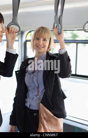 Lächelnde Geschäftsfrauen, die Fahrt mit dem bus Stockfoto