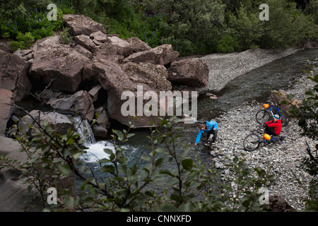 Paar Kreuzung Creek mit Fahrrädern Stockfoto