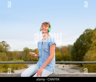 Frau, zuhören, Kopfhörer im freien Stockfoto