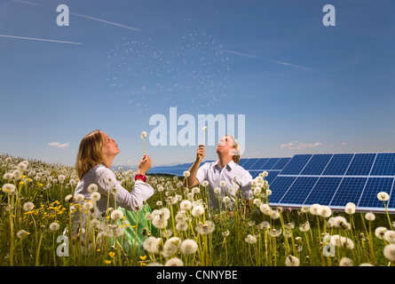 Paar im Feld mit Sonnenkollektoren Stockfoto