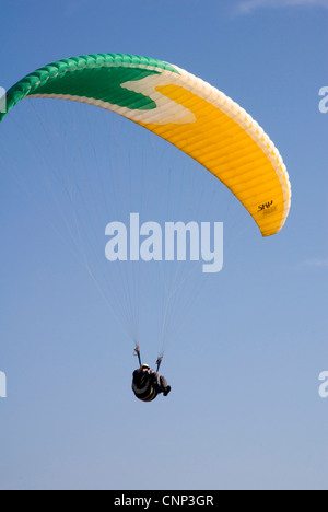 Para Glider - grün weißen und gelben Baldachin über - Reiten die Brise - Hintergrund blauer Himmel Stockfoto