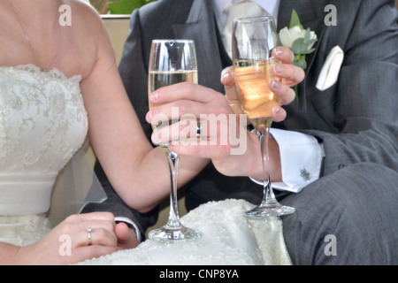 Frisch verheiratetes Paar Gläser Champagner hält hautnah. Stockfoto