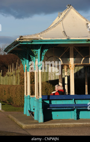 Ein älteres Ehepaar sitzt in einem reich verzierten viktorianischen Tierheim, Southport Marine Park Stockfoto