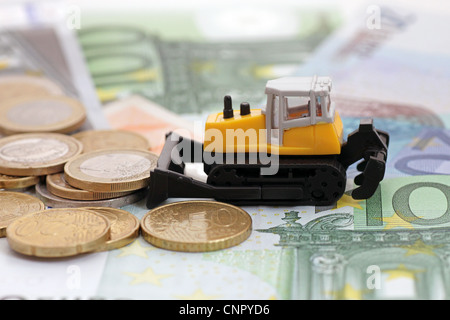 haufenweise Geld kassieren: Traktor schieben Haufen von Münzen Stockfoto