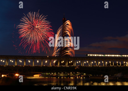 Parisern und Touristen beobachten Bastille Day Feuerwerk rund um den Eiffelturm mit Passy Brücke im Vordergrund in Paris, Frankreich. Stockfoto