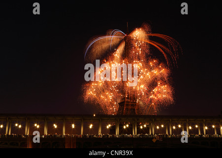 Parisern und Touristen beobachten Bastille Day Feuerwerk rund um den Eiffelturm mit Passy Brücke im Vordergrund in Paris, Frankreich. Stockfoto