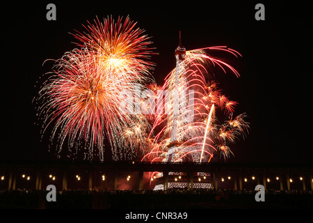 Parisern und Touristen beobachten Bastille Day Feuerwerk rund um den Eiffelturm mit Passy Brücke im Vordergrund in Paris, Frankreich. Stockfoto