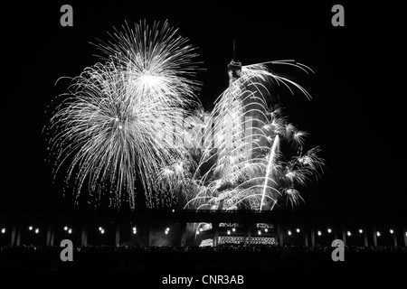 Parisern und Touristen beobachten Bastille Day Feuerwerk rund um den Eiffelturm mit Passy Brücke im Vordergrund in Paris, Frankreich. Stockfoto