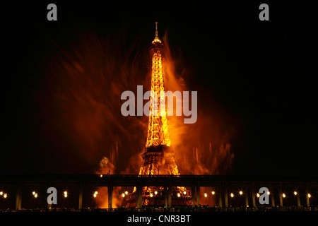 Parisern und Touristen beobachten Bastille Day Feuerwerk rund um den Eiffelturm mit Passy Brücke im Vordergrund in Paris, Frankreich. Stockfoto