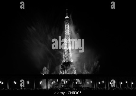 Parisern und Touristen beobachten Bastille Day Feuerwerk rund um den Eiffelturm mit Passy Brücke im Vordergrund in Paris, Frankreich. Stockfoto