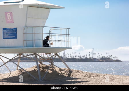 Leben bewachen Rettungsschwimmer Station Hütte in Long Beach Ca California mit Insel Chaffee einer Offshore-Bohrinsel verkleidet mit Palmen Stockfoto