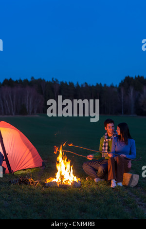 Camping Nacht paar kochen durch Lagerfeuer Rucksack in romantische Landschaft Stockfoto