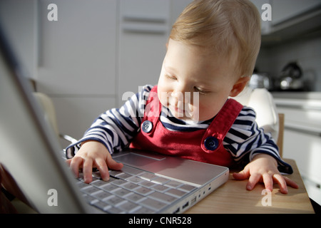 Babymädchen spielen mit Laptop, London, England Stockfoto