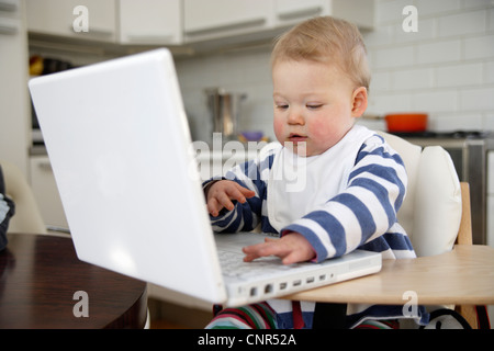 Babymädchen spielen mit Laptop, London, England Stockfoto