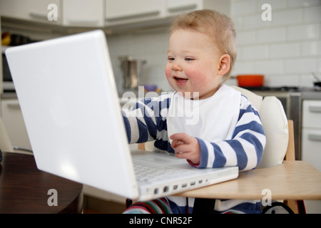 Babymädchen spielen mit Laptop, London, England Stockfoto