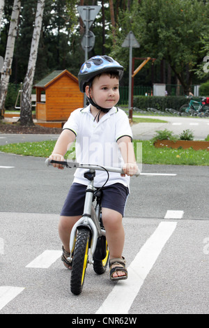 Baby Boy am Verkehrsgarten für Kind mit Helm Stockfoto