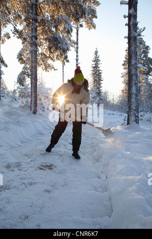 Schneeschaufeln auf ländlichen Weg Mann Stockfoto