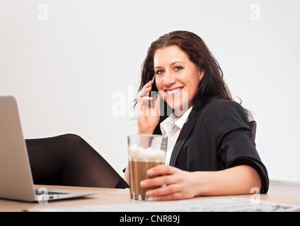 Porträt eines jungen Profis im Büro mit ihrem Telefon, um mit jemandem zu sprechen Stockfoto