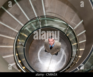 Geschäftsmann, stehen in der Wendeltreppe Stockfoto